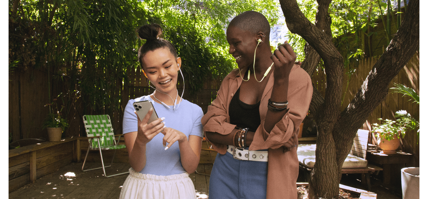 مردی  و زنی با هدفون Beats Flex زرد در گوش در حال استفاده روزمره